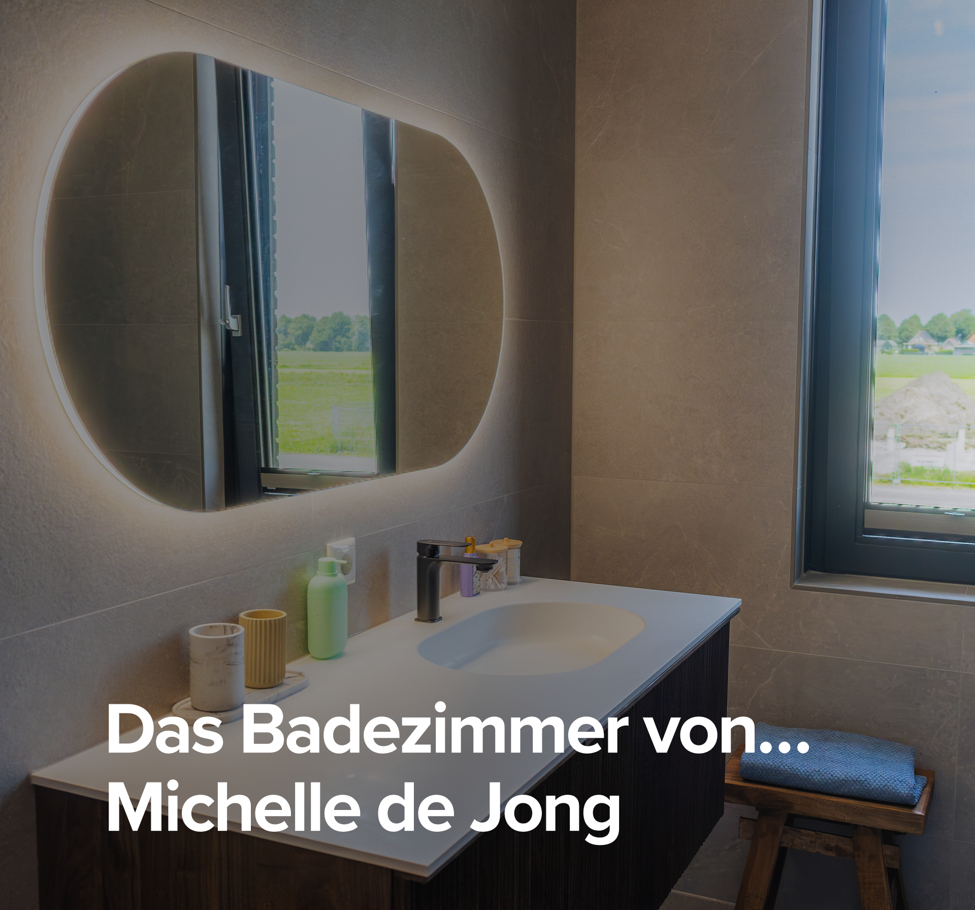 Überblick über das Badezimmer von Michelle de Jongg mit modernem Waschtisch, beleuchtetem Spiegel und Glasduschwand.