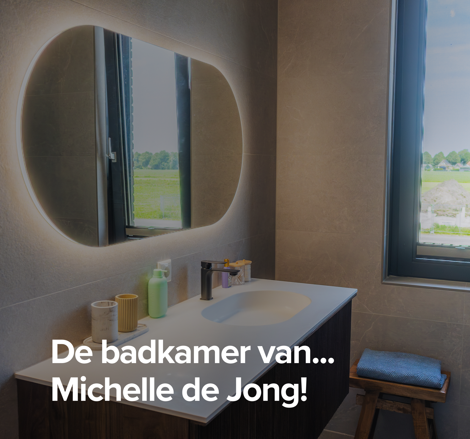 Overzicht van Michelle de Jongg’s badkamer met modern badkamermeubel, verlichte spiegel en glazen douchewand.