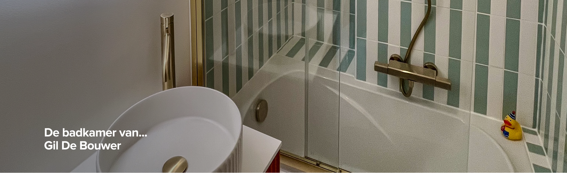 Badkamer van Gil De Bouwer met verticale groen-witte wandtegels, gouden badkraan en X2O eendje op de badrand – een realisatie van x2o badkamers.