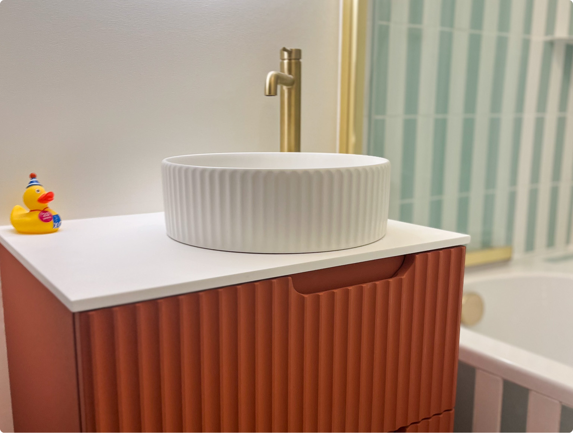 Detail van het X2O badkamermeubel in oranje ribbelstructuur met witte waskom, lade in geopende stand.