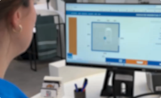 Du siehst, wie eine Mitarbeiterin auf einen Bildschirm schaut, auf dem ein Badplan mit Maßen im x²o badkamers Planungsprogramm dargestellt wird.