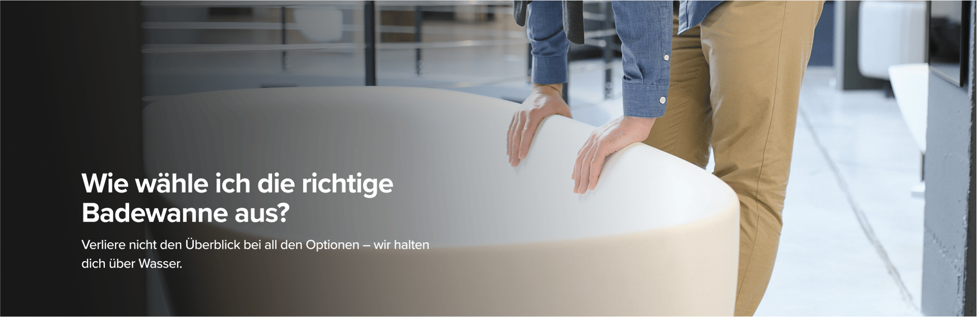 Auf diesem Bild von x²o badkamers siehst du einen Mann in beiger Hose und blauem Hemd, der eine große Designer-Badewanne von x²o badkamers in einem Showroom mit Industrie-Boden und anderen Badmodellen im Hintergrund begutachtet.