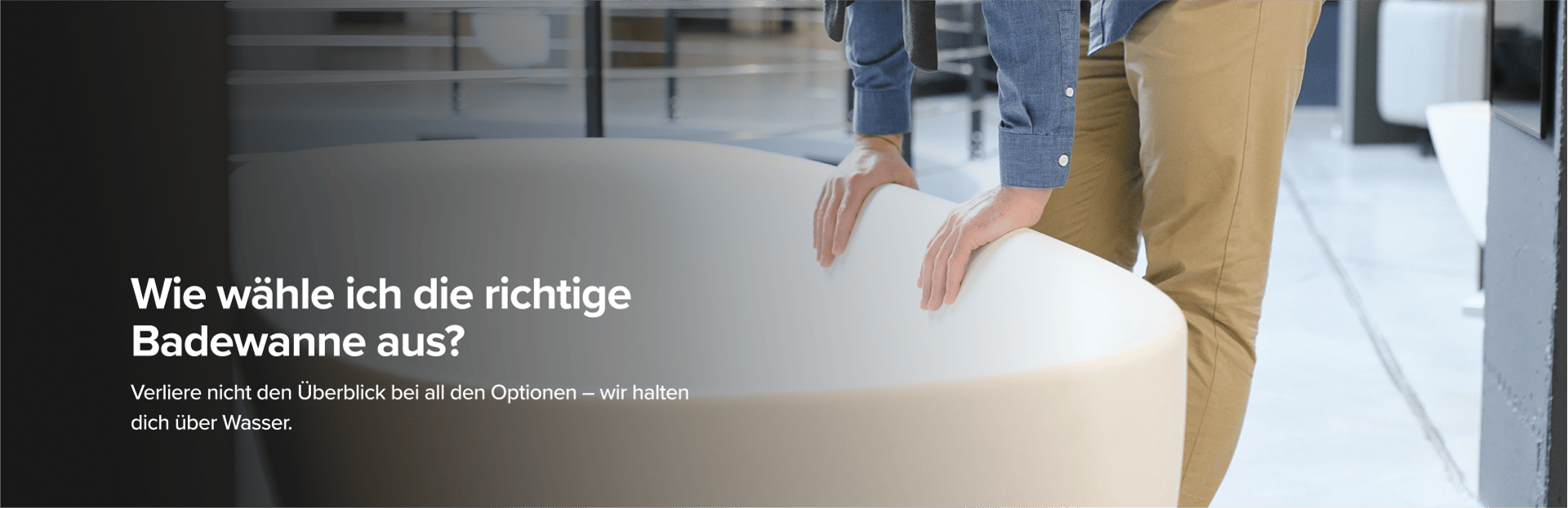 Auf diesem Bild von x²o badkamers siehst du einen Mann in beiger Hose und blauem Hemd, der eine große Designer-Badewanne von x²o badkamers in einem Showroom mit Industrie-Boden und anderen Badmodellen im Hintergrund begutachtet.