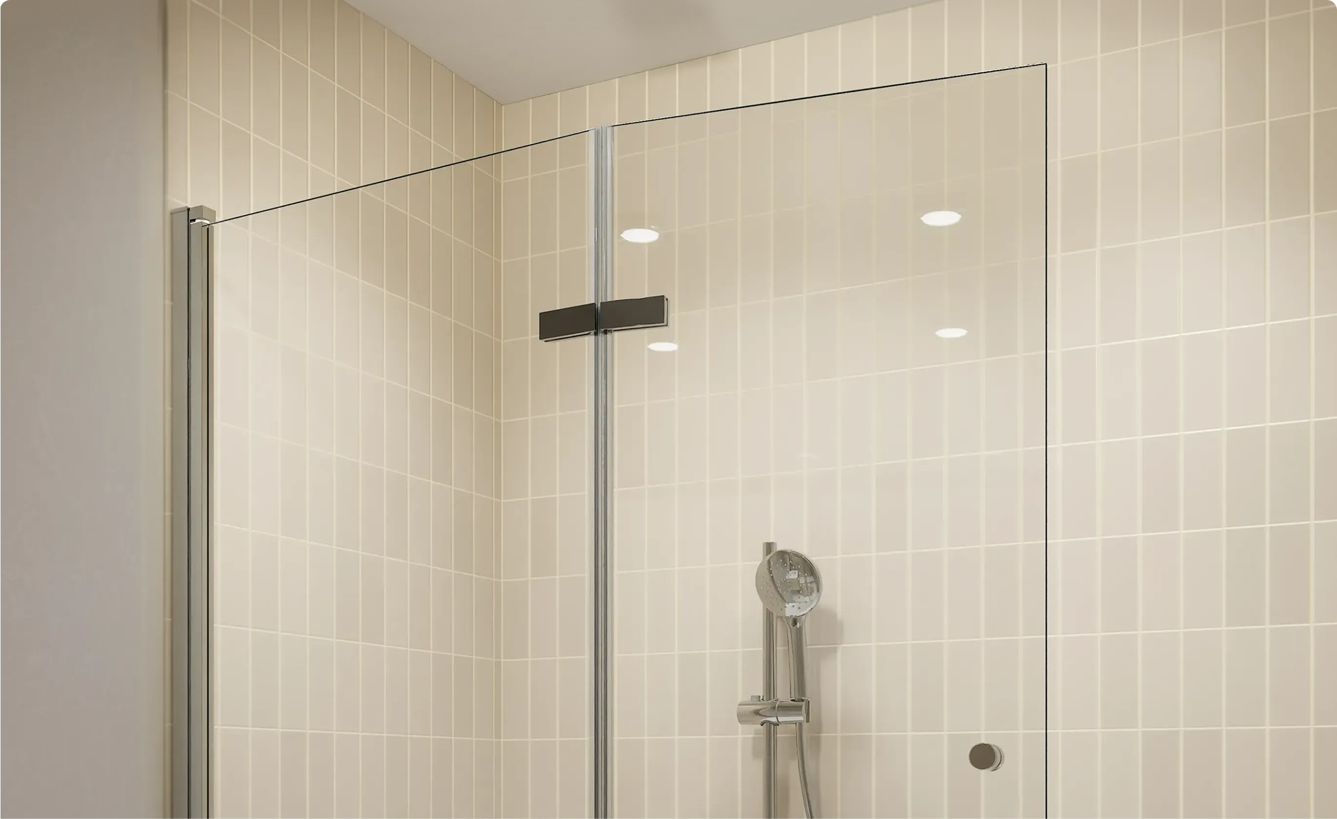 Transparante glazen douchewand met zwart bevestigingsprofiel, geplaatst voor crèmekleurige verticaal geplaatste metrotegels en een chromen handdouche, in een badkamer van x²o badkamers.