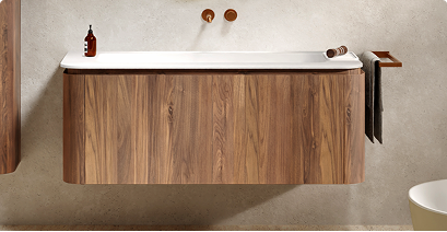 Badkamermeubel in warme houtlook met wit wastafelblad, wandgemonteerd, met minimalistische accessoires – te zien bij x²o badkamers.