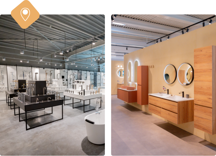 Mitarbeiterin von x²o Badezimmer lächelt neben einem rosafarbenen Waschtisch mit tropischer Tapete und Designbeleuchtung.