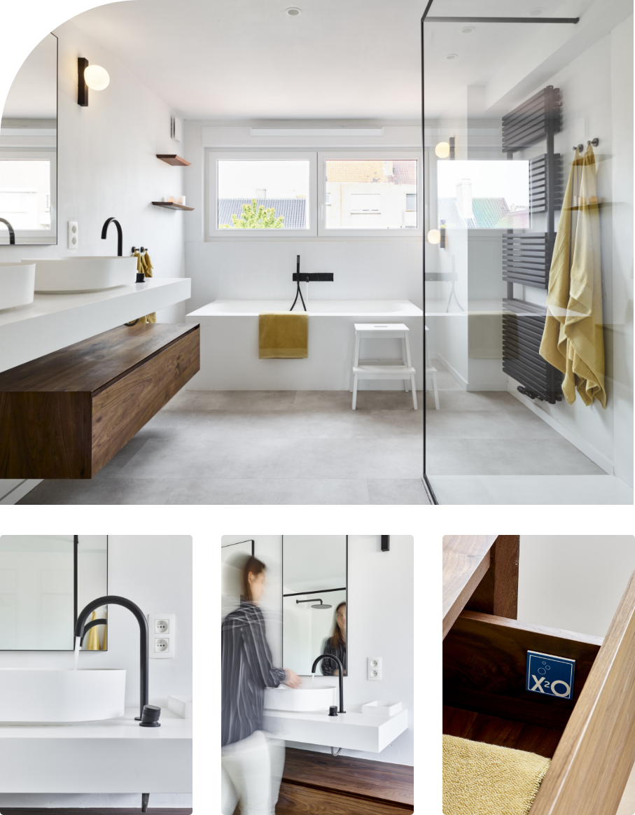 Schwarze Badewannenarmatur an einer weißen Fliesenwand.