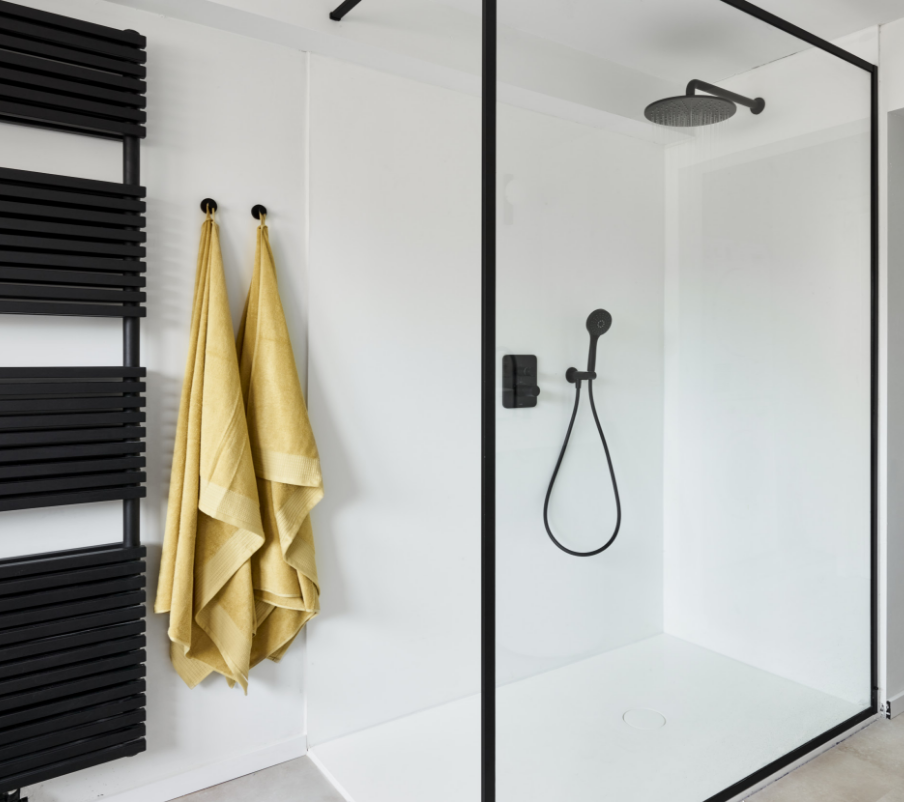 Begehbare Glasdusche mit schwarzer Regendusche und Handtuchheizkörper.