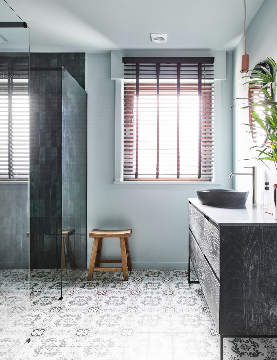 Luxuriöses Badezimmer mit schwarzem Waschbecken und Holzwaschtisch.