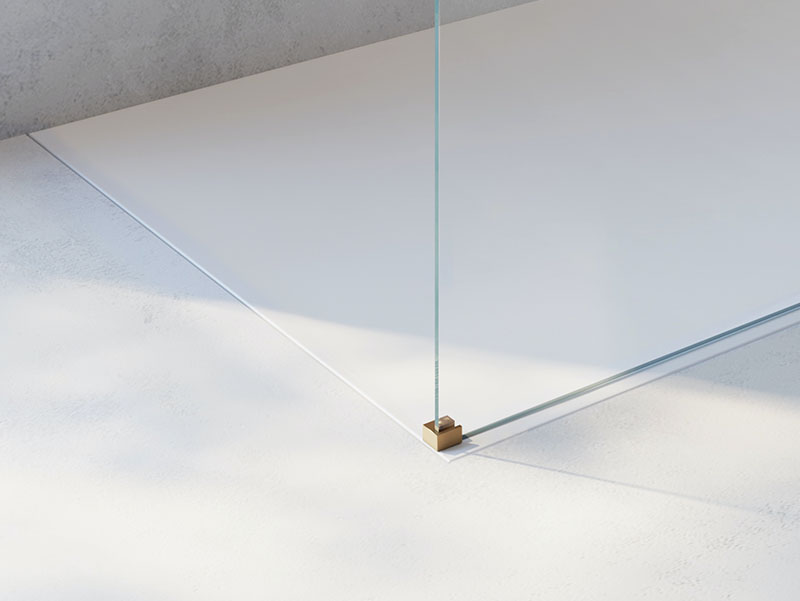 Detail van een moderne inloopdouche met goudkleurige douchearmatuur en handdouche, bevestigd aan een lichte wand met subtiele textuur voor een luxueuze uitstraling.