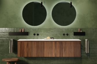 Moderne badkamer met houten wastafelmeubel, groene tegels en ronde spiegels met verlichting.