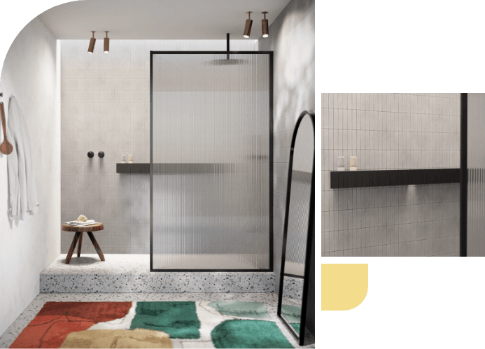 Badkamer met een douchewand van zwart metaal, minimalistisch design en kleurrijk vloerkleed.