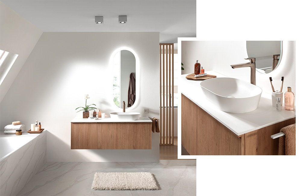 Schlichtes Badezimmer mit Holz-Waschbeckenmöbel, weißem Waschbecken, beleuchtetem Spiegel und modernem Wasserhahn.