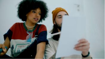 Femme et homme regardent ensemble un document dans un environnement calme.