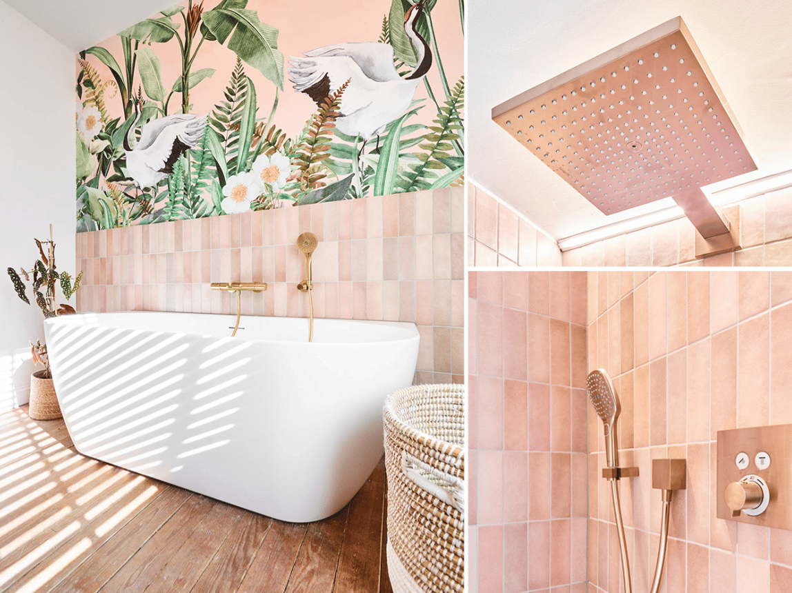 Salle de bain moderne avec baignoire autoportante, robinets dorés, décoration murale tropicale et douche à effet pluie