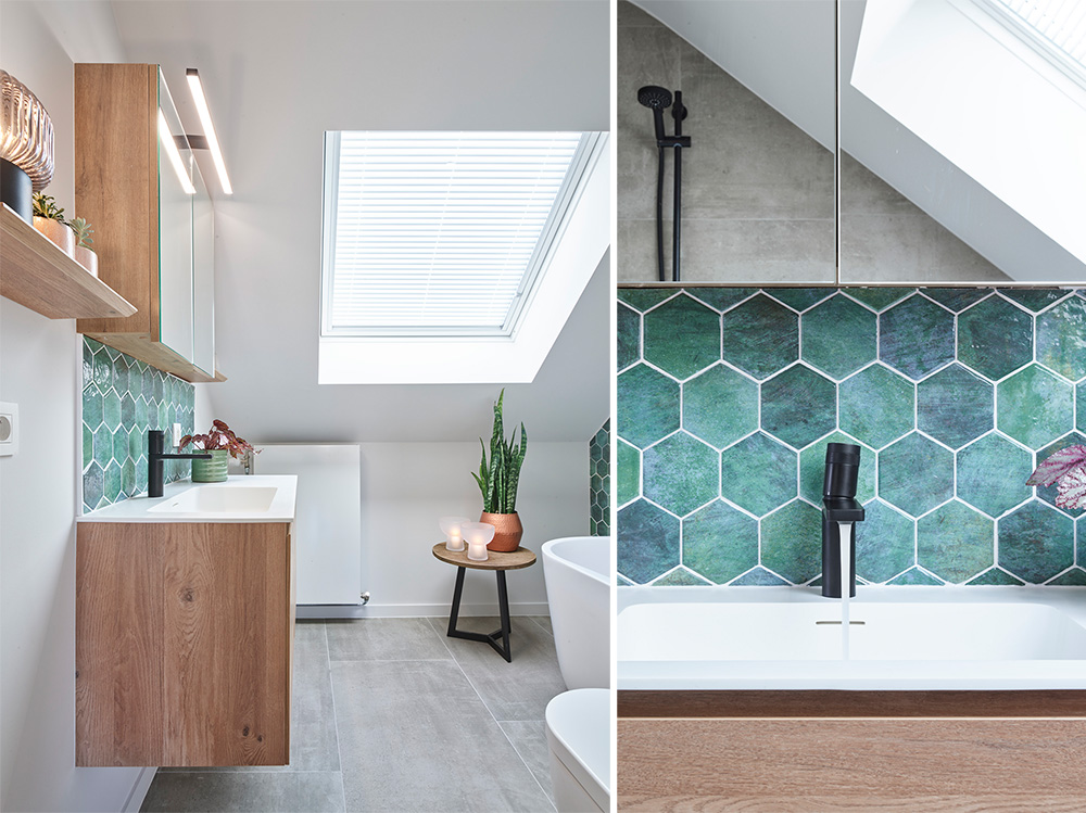 Badkamer met een wastafelmeubel, groene tegelwand, toilet, bad en planten onder een dakraam.