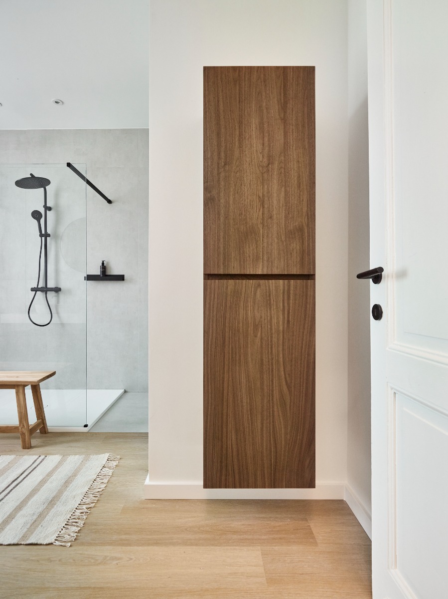 Armoire en bois dans une salle de bain moderne avec une douche à l'italienne et un banc en bois.