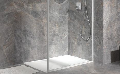 Lage witte douchebak geïntegreerd in een moderne badkamer van x²o badkamers, omringd door grijze natuursteenlook wand- en vloertegels die zorgen voor een strakke en onderhoudsvriendelijke afwerking.