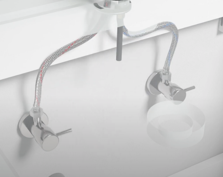 Detailbeeld van flexibele waterslangen en afsluitkranen onder een wastafel, zichtbaar als technisch onderhoudsvoorbeeld bij x²o badkamers.