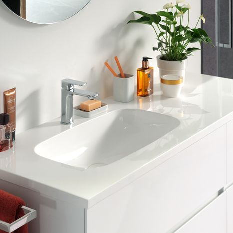 Integriertes weißes Waschbecken mit sanft gerundeten Formen in einem glänzend weißen Möbel, mit Chromarmatur, aus dem Sortiment von x²o Badezimmer.