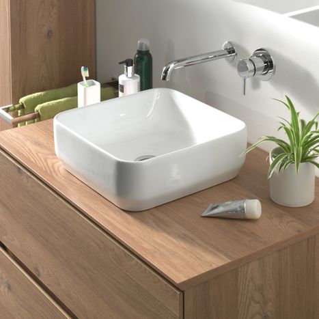 Schwarzes rechteckiges Waschbecken in eine dunkle Platte integriert, mit verchromter Armatur und Pflegeprodukten, Teil eines modernen x²o Badezimmermöbels.