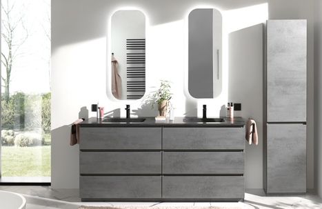 Miroir de salle de bains rond avec bord fin fixé sur un mur en pierre naturelle claire dans une salle de bains moderne de x²o salles de bains. Sous le miroir se trouve un meuble lavabo suspendu en bois à structure verticale avec une vasque blanche posée. À gauche, un porte-serviettes avec une serviette claire, à droite une douche à l’italienne avec paroi en verre, douche pluie et niche murale avec accessoires.