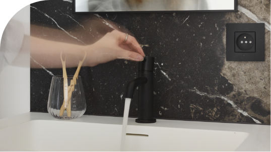 Detail einer eleganten Badarmatur über einer Waschschale in einem modernen Badezimmer von x²o Badezimmer.