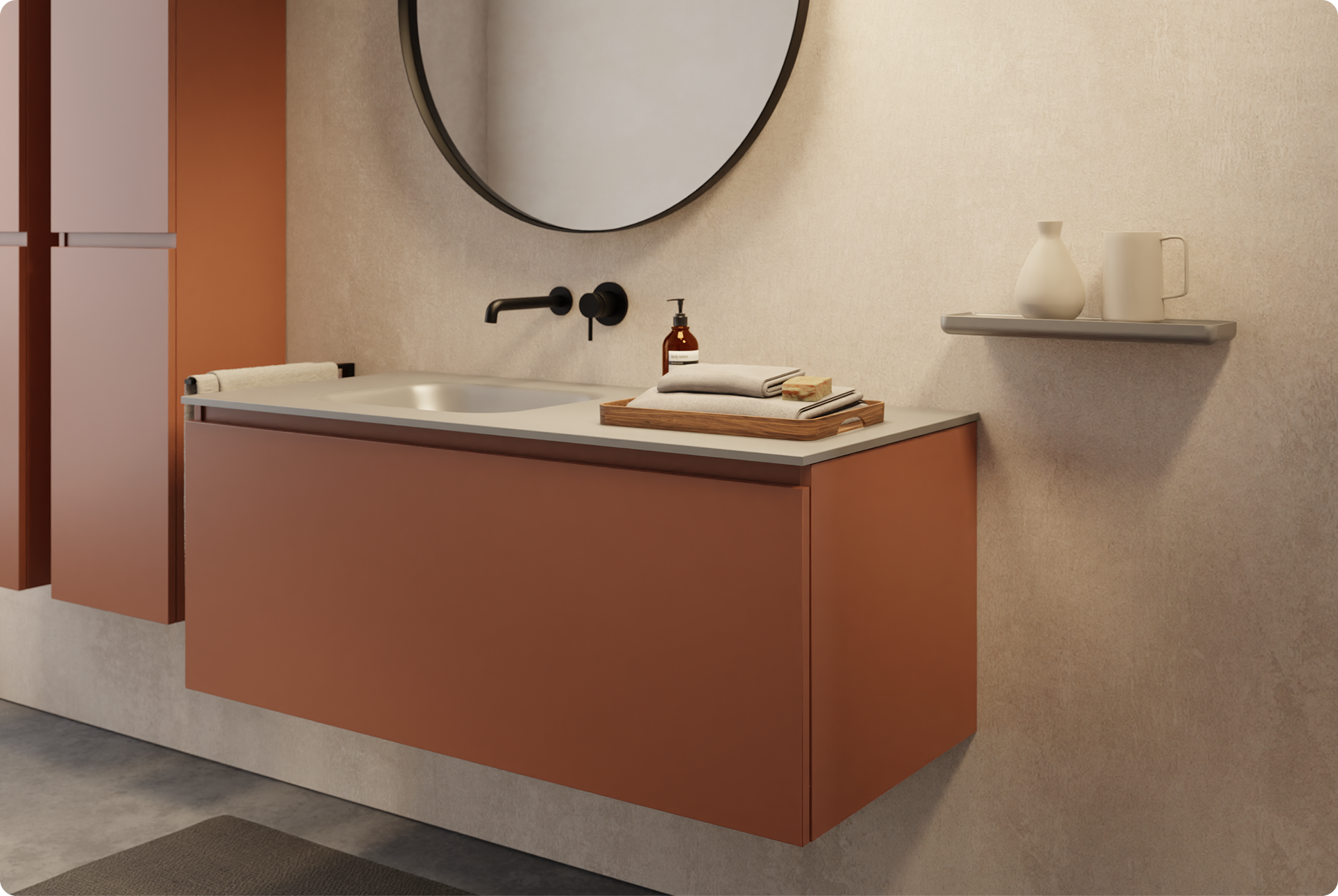 Warme Atmosphäre im x²o Badezimmer mit schwebendem Waschschrank in Rostfarbe, mattschwarzer Armatur und rundem Spiegel mit schwarzem Rand. Die beigefarbene Wand und Accessoires wie das Holztablett und Keramik sorgen für eine natürliche, beruhigende Ausstrahlung.