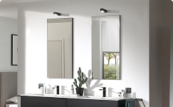 Du siehst eine moderne Badezimmereinrichtung von x²o Bad mit einem breiten Spiegelschrank über einem Doppelwaschtisch. Der Spiegelschrank verfügt über integrierte Beleuchtung und spiegelt ein helles, minimalistisches Badezimmer wider.