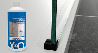 Produit d’entretien X²O à côté d’une paroi de douche avec revêtement transparent.