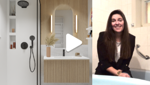 Video-thumbnail met een vrouw die glimlachend in een badkamer zit, naast een modern toilet en douche, met een afspeelicoon dat aangeeft dat het om een video gaat.
