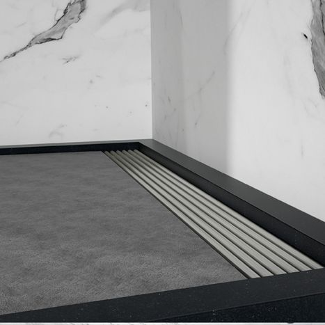 Detailaufnahme einer hellgrauen Duschwanne mit integrierter Linienablauf-Rinne, kombiniert mit Wandfliesen in Marmoroptik. Der Ablauf ist sauber entlang des Randes verarbeitet. Diese Lösung von x²o Badezimmer zeigt eine besonders pflegeleichte Duschgestaltung.