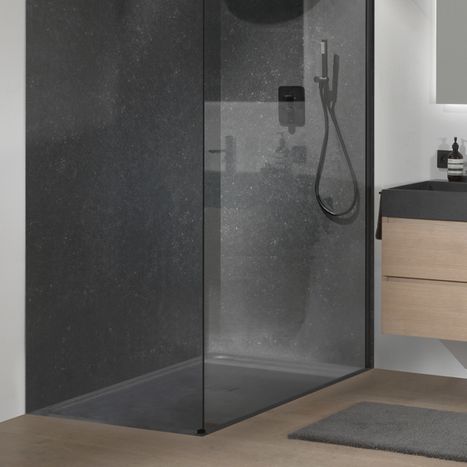 Moderne bodengleiche Dusche mit dunkelgrauer Duschwanne und getönter Glaswand, neben einem Badmöbel aus Holz. Graue Boden- und Wandfliesen sorgen für een harmonisches Gesamtbild. Diese Dusche von x²o Badezimmer steht für Langlebigkeit und einfache Pflege.