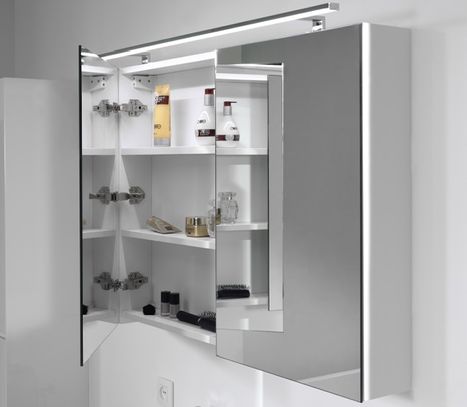 Moderne badkamer van x²o badkamers met een zwevend badkamermeubel in licht hout onder een schuin dak. Boven het meubel hangen twee rechthoekige spiegels met geïntegreerde verlichting. Links staat een groene kamerplant, rechts is een inloopdouche zichtbaar met glazen wand en lichte wandbekleding. De ruimte is helder en functioneel ingericht.
