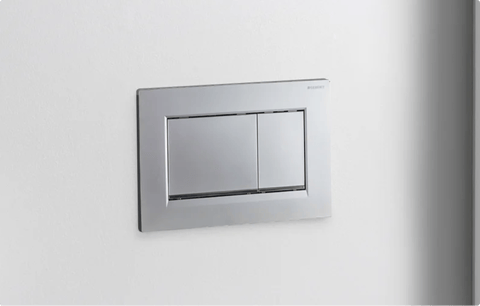 Moderne Geberit Betätigungsplatte in Chromoptik von x²o Badezimmer für die Zweimengenspülung an einer weißen Wand.