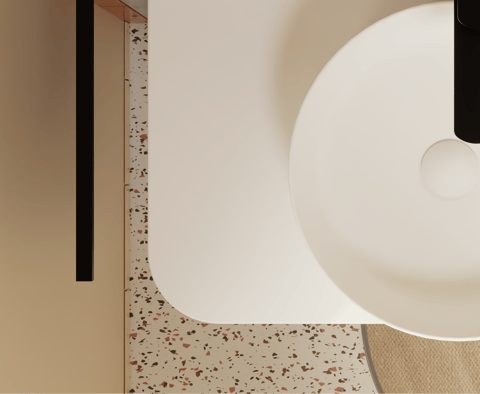 Moderne wastafel van x²o badkamers met organische afgeronde vorm op een terrazzo blad met zachte kleuren en minimalistische uitstraling.