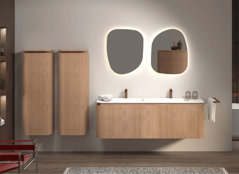 Stijlvolle badkamer van x²o badkamers met houten wastafelmeubel, organisch gevormde spiegels met verlichting en warme sfeerverlichting.