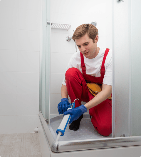 Fachmann trägt Silikon auf den Rand der Duschwanne auf – X²O Badezimmer