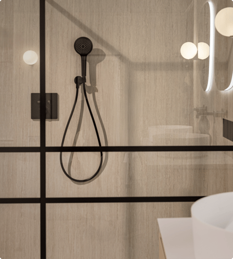 Dusche mit schwarzem Handbrausekopf und industrieller Glaswand in einem stilvollen Badezimmer von X²O Badezimmer.