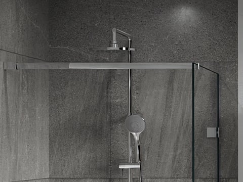Detail van een moderne inloopdouche met glazen wand, regen- en handdouchekoppen.