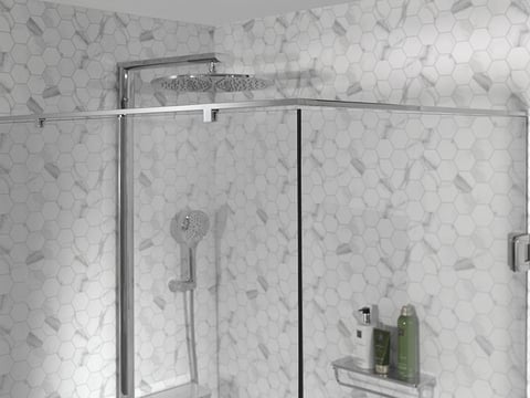 Moderne inloopdouche met glazen wand, regendouche en hexagonale marmeren tegels.