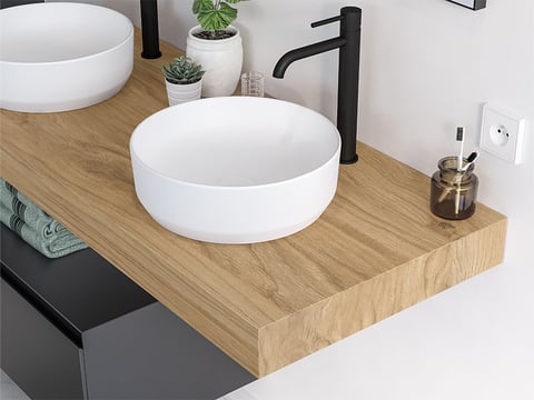 Moderne houten wastafel met opzetwaskom in wit keramiek en matzwarte kraan voor een stijlvolle badkamer.
