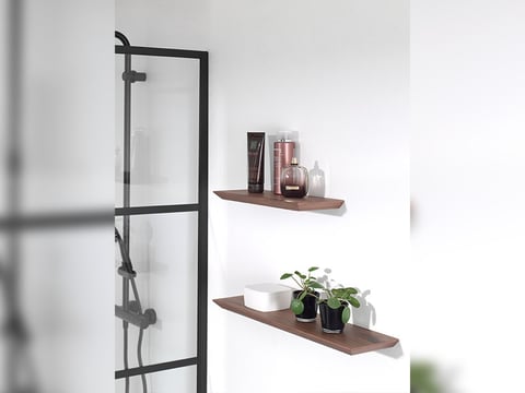 Houten wandplanken in de badkamer voor decoratie en opslag, minimalistisch ontwerp naast de douche.