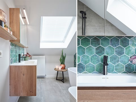 Badkamer met een wastafelmeubel, groene tegelwand, toilet, bad en planten onder een dakraam.