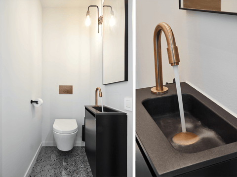 Douche à l’italienne industrielle de x²o salles de bains avec une paroi de douche noire, un revêtement mural en terrazzo et une douche pluie en cuivre avec douchette.