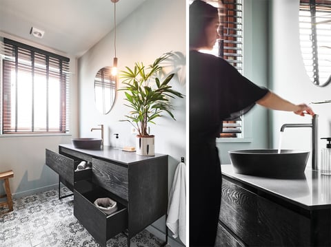Zwarte designkraan van x²o badkamers boven een donkere wastafel, gefotografeerd met focus op vorm, kleur en materiaal.