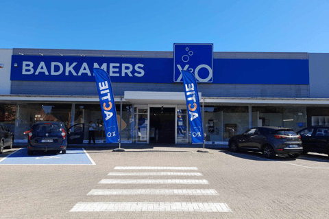 X²O Badkamers winkel met ingang, parking en promotievlaggen voor de deur – X²O badkamers