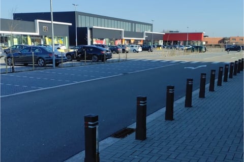 Parking x²o salles de bains à Bree avec plusieurs voitures et accès au showroom en arrière-plan.