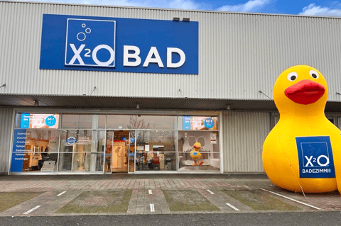 X²O Badezimmer Geschäft mit großer aufblasbarer Ente und verglastem Eingang mit sichtbarem Showroom – X²O Badezimmer