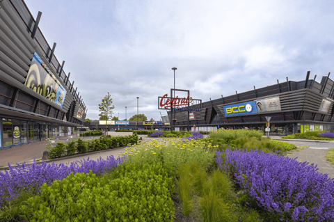 Modern winkelcentrum met verzorgde groenzones, diverse winkels en een aangename, toegankelijke omgeving voor een complete shoppingervaring – X²O badkamers